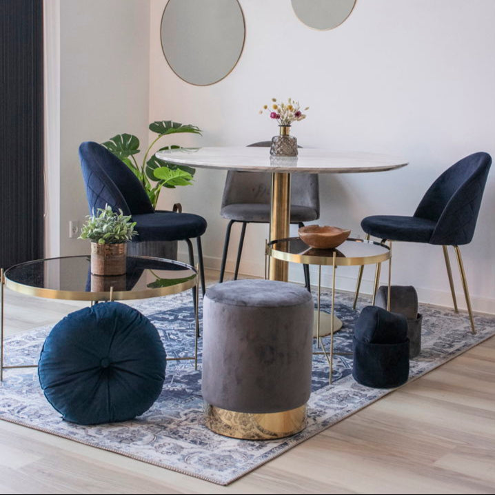 Geneve spisestoler i blå velur med messingben plassert ved bord – elegant spisestueløsning.