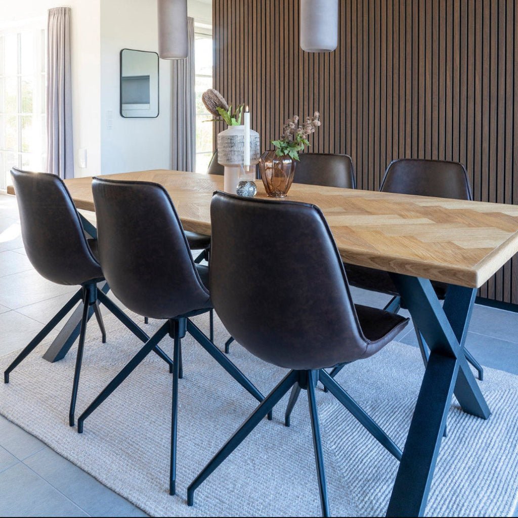 Mørkebrune Monaco spisestole rundt et spisebord i et moderne interiør med lyst gulv og en mørk vegg