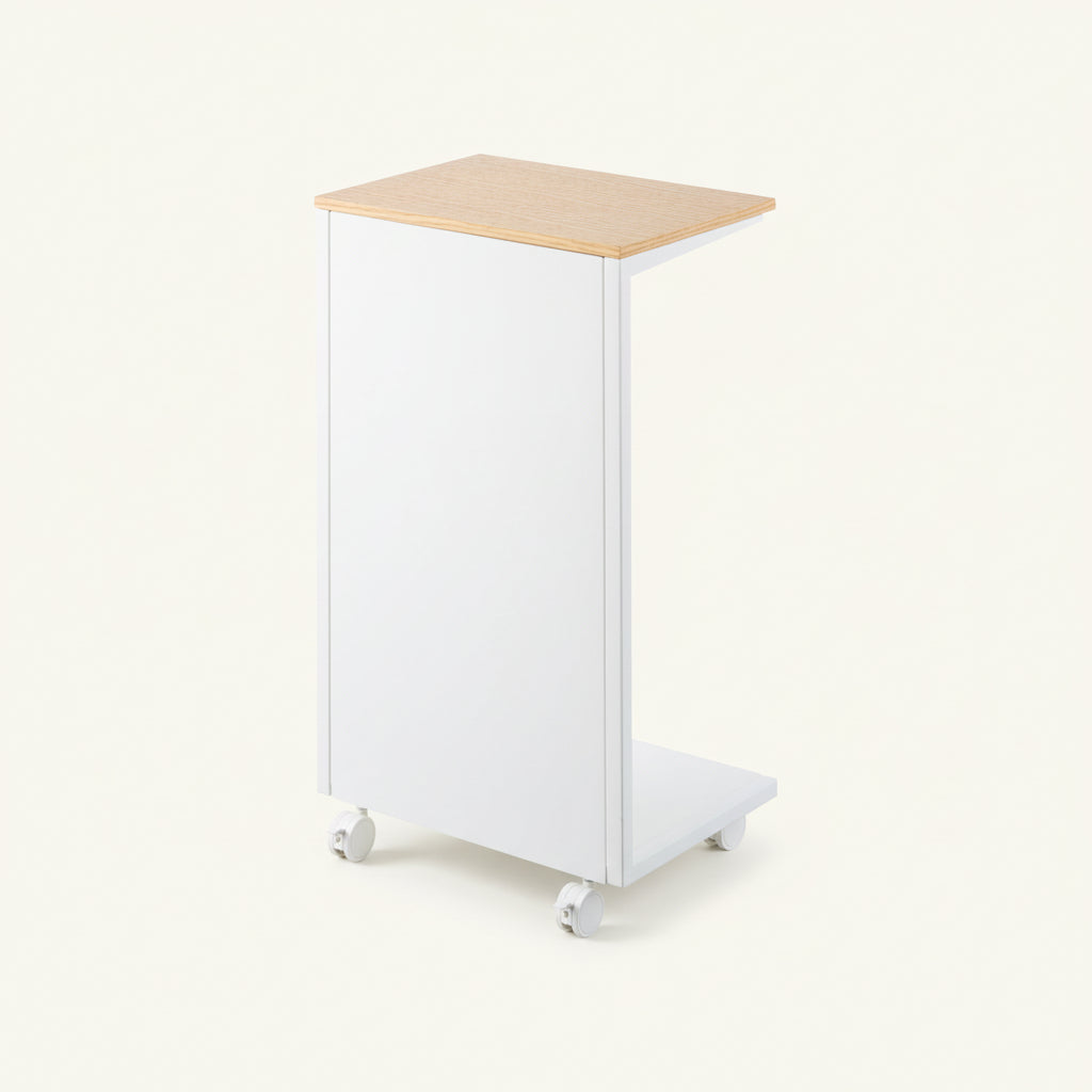 Sidebord med lys treplate og hvit ramme brukt som nattbord på soverom.