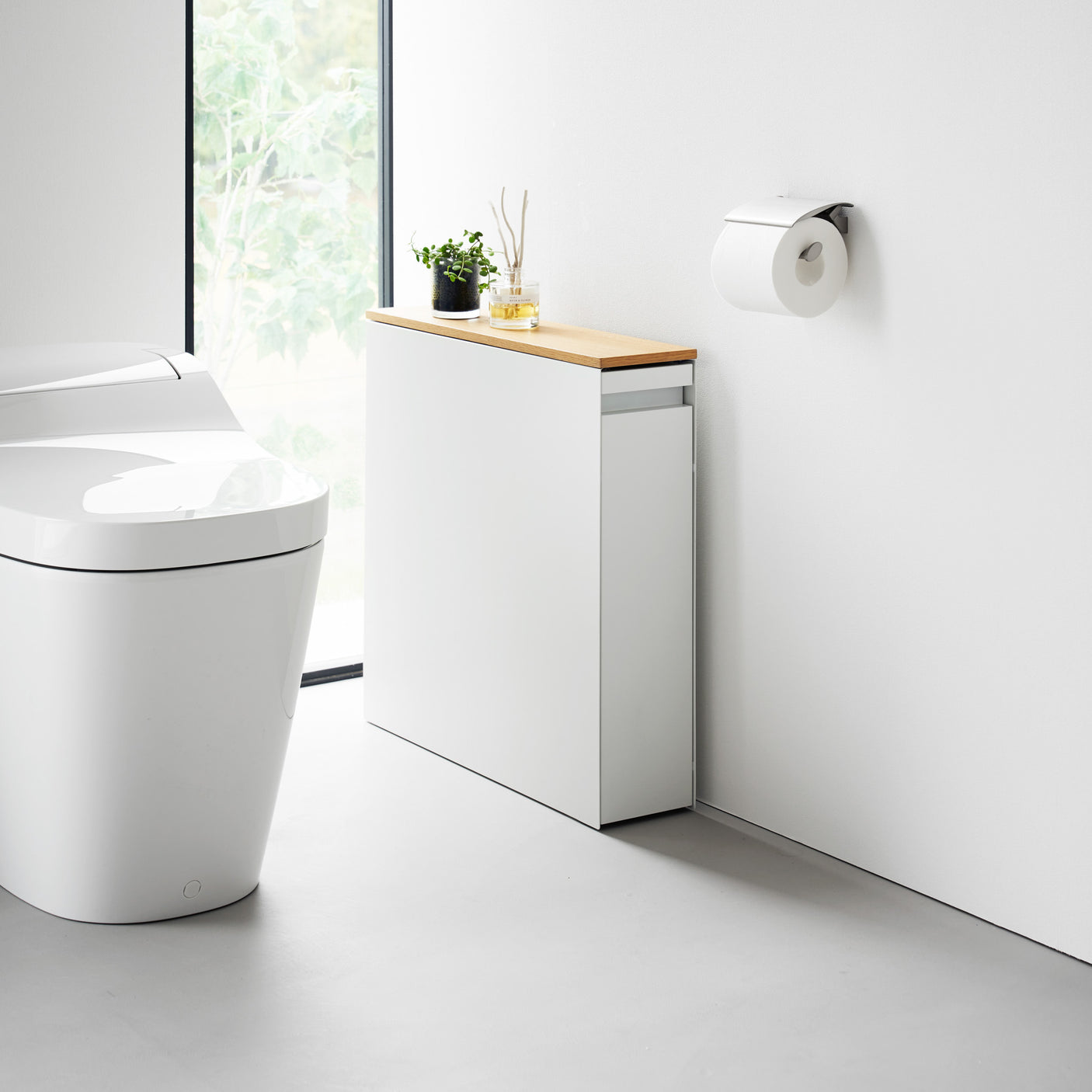 Hvit oppbevaringsenhet med skyvbar dør og treplate på toppen, brukt til husholdningsartikler.