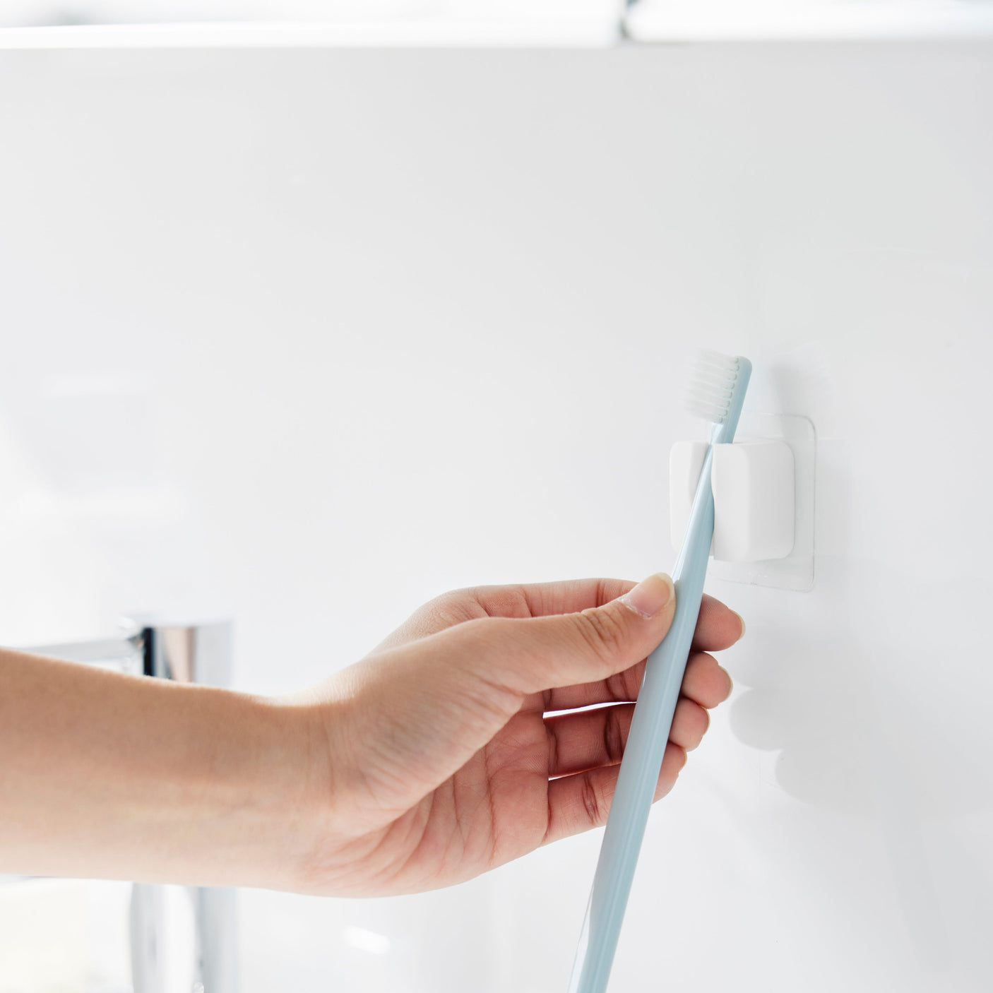 Selvklebende holder med fleksibel klemme for oppbevaring.