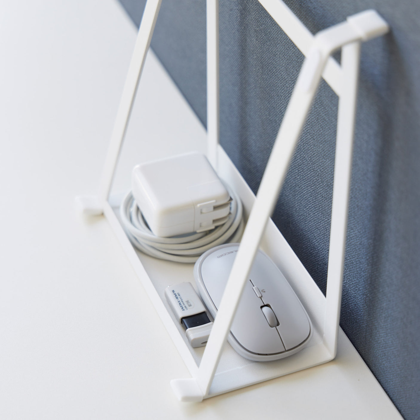 Hvit sammenleggbar laptopholder på skrivebord med datamaskin.