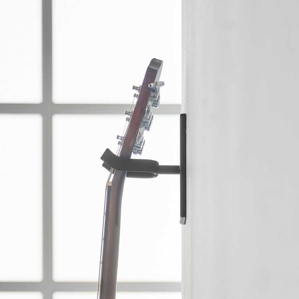 Plassbesparende veggfeste for gitarer.