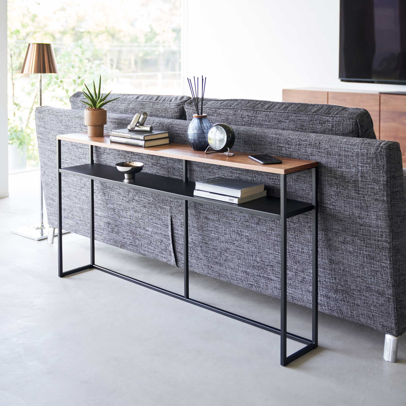 Treplate og sort ramme på moderne konsollbord i stue.