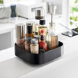 Roterende oppbevaringsbrett i sort for organisering av kjøkkenartikler.