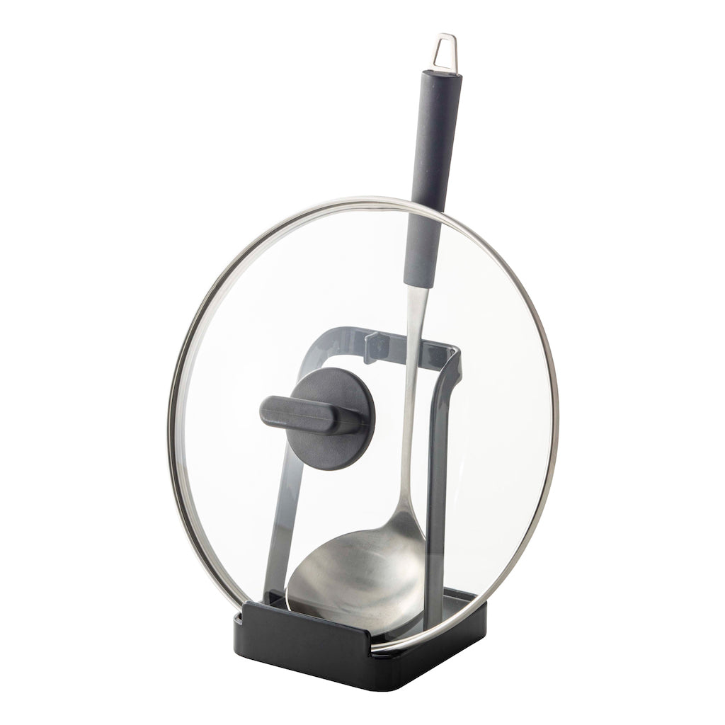 Stativ for kjøkkenredskaper i sort, holder grytesleiv og lokk ryddig under matlaging.