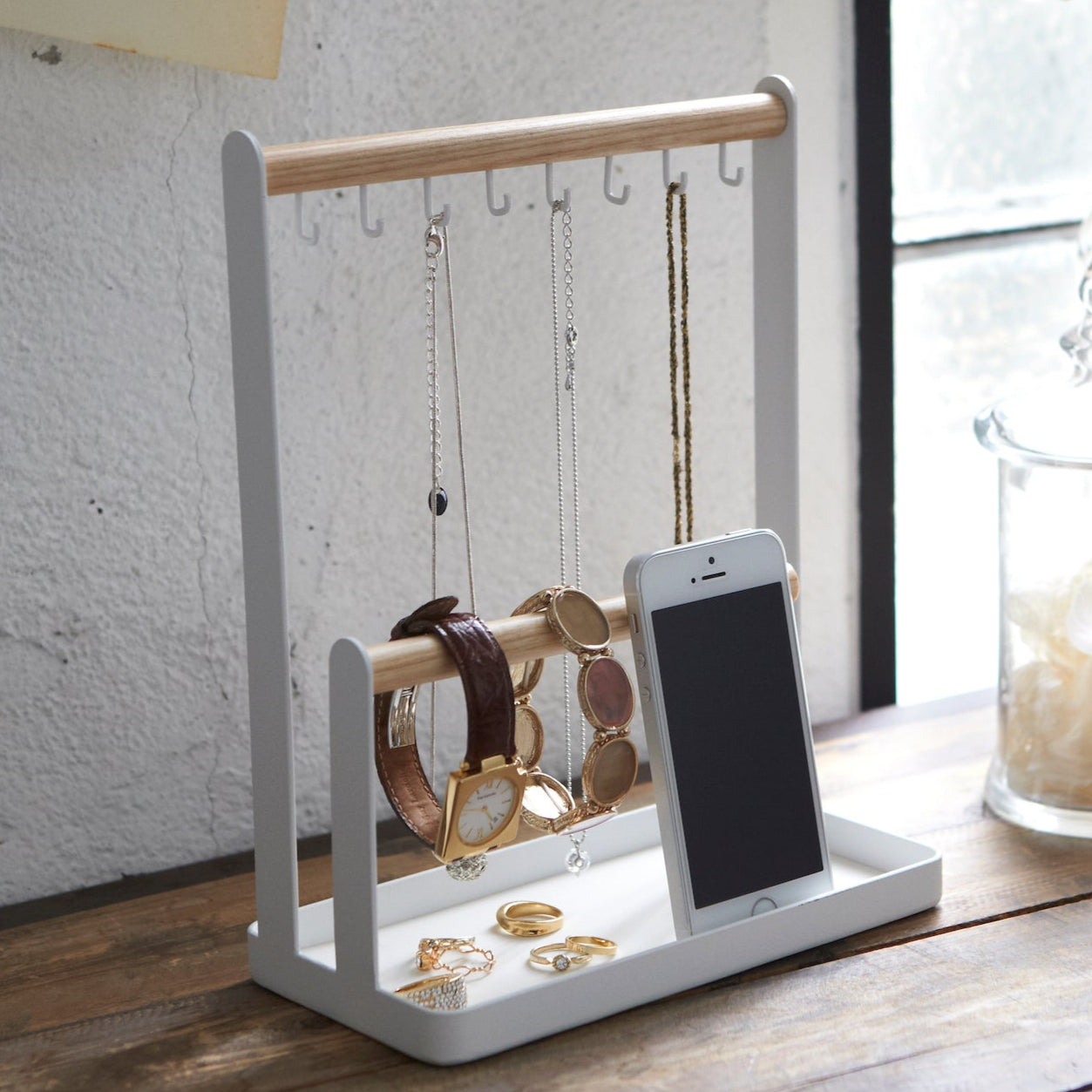 Smykkestativ med kroker og en oppbevaringsskål for små tilbehør.