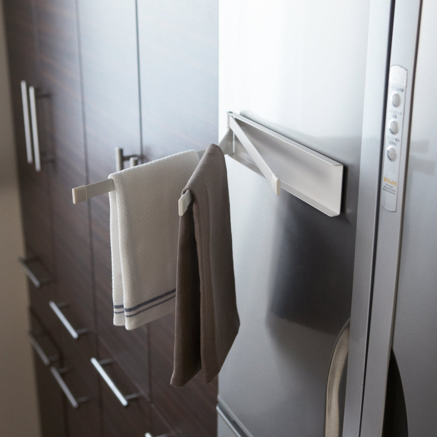 Magnetisk håndkleholder i bruk med flere håndklær hengende for tørk.