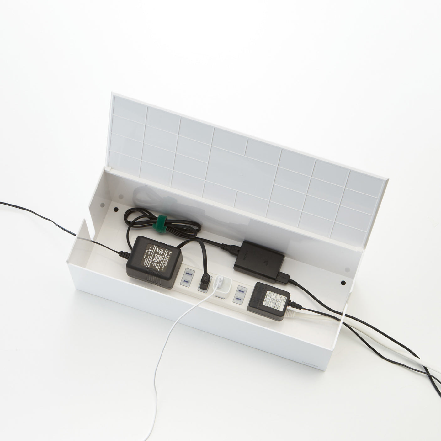 Minimalistisk kabelorganisering med stikkontakt og ladere.