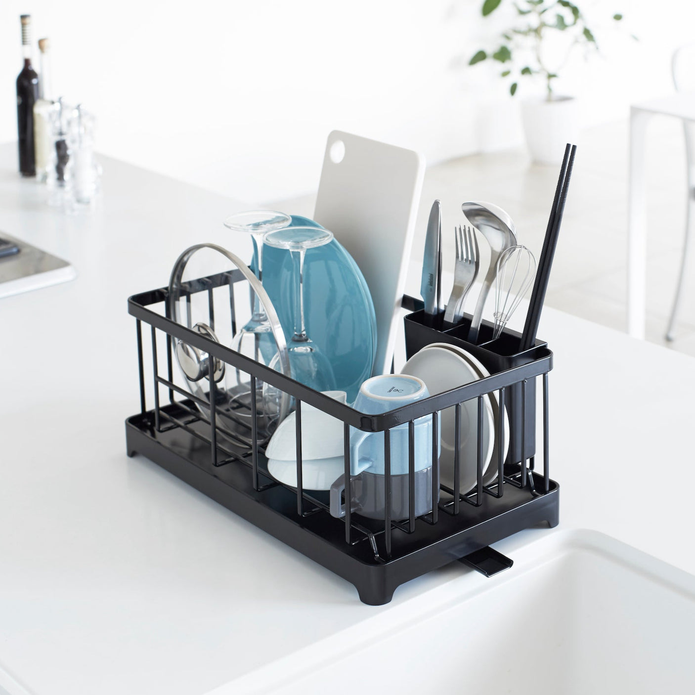 Elegant oppvaskstativ i sort metall med en smart drypprenne for effektiv avrenning.