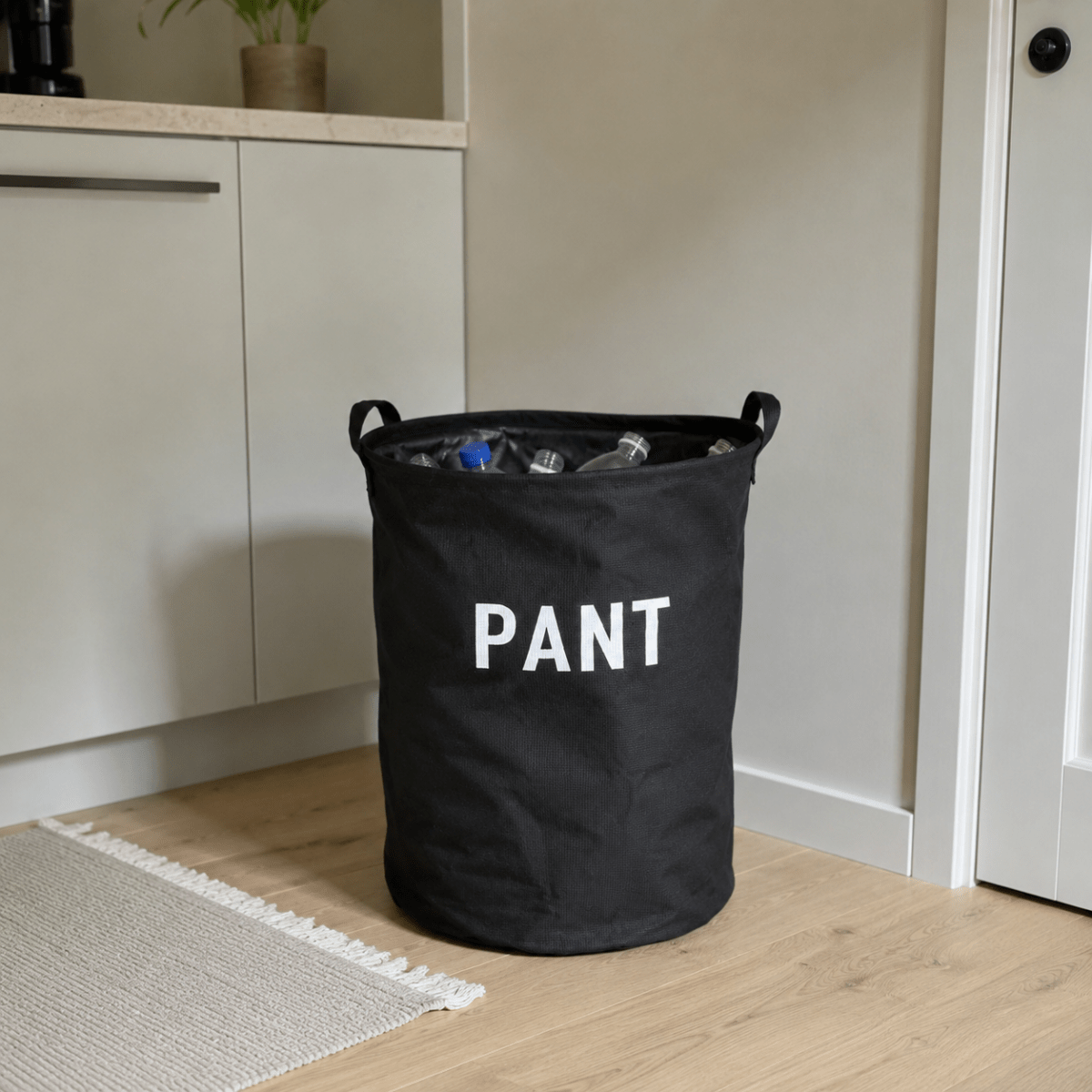 Sort pantpose med flasker og bokser i en norsk bod
