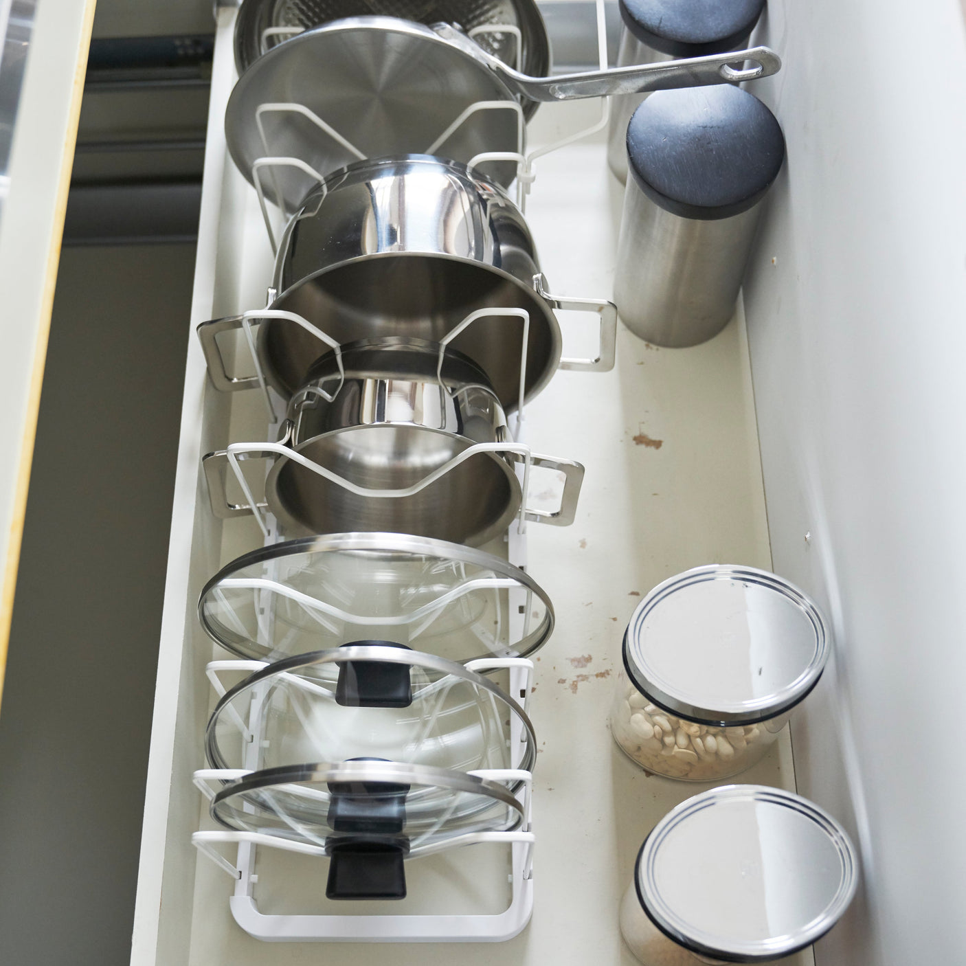 Plassbesparende stativ for stekepanner, kasseroller og lokk.