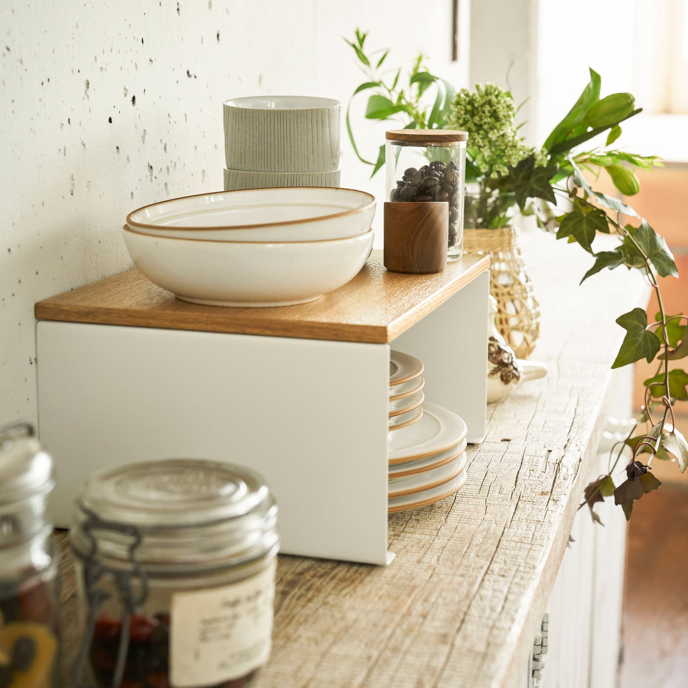 Hvit metallhylle brukt til å stable skåler og tallerkener.