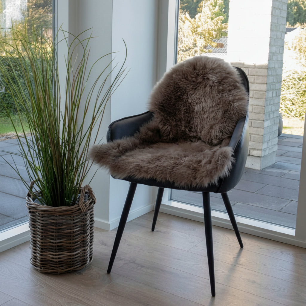 Elegant grÄ lammeskinn brukt pÄ moderne stol for myk komfort.