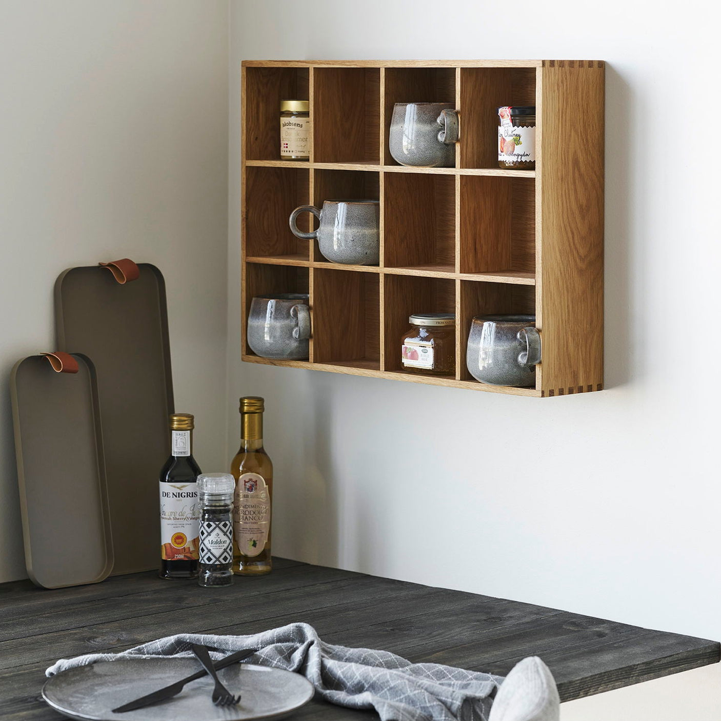 ia vegghylle montert i moderne gang med dekorative gjenstander og planter"