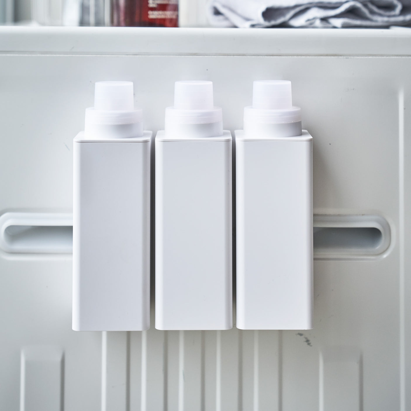 Detaljbilde av hvit magnetisk flaske montert på metallflate.