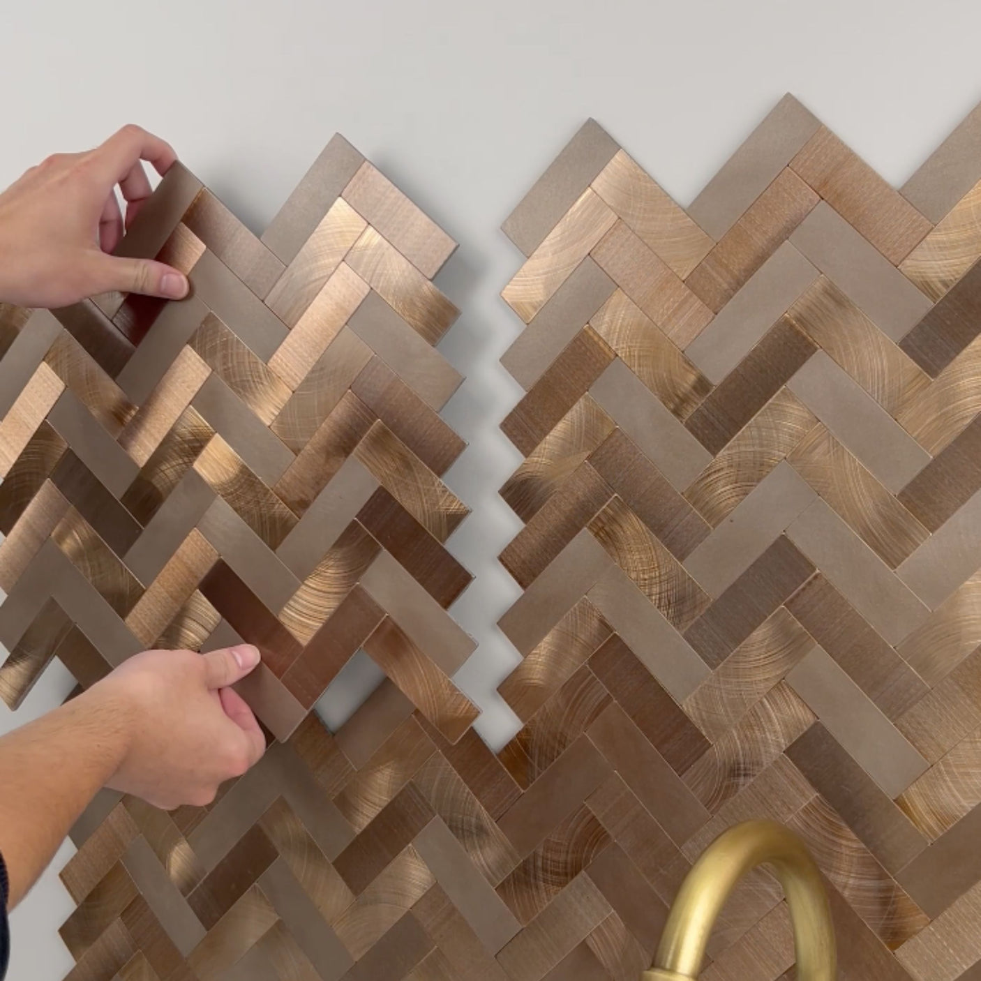 Detaljbilde av Sofie fiskebein veggfliser med kobberfarge og herringbone mønster