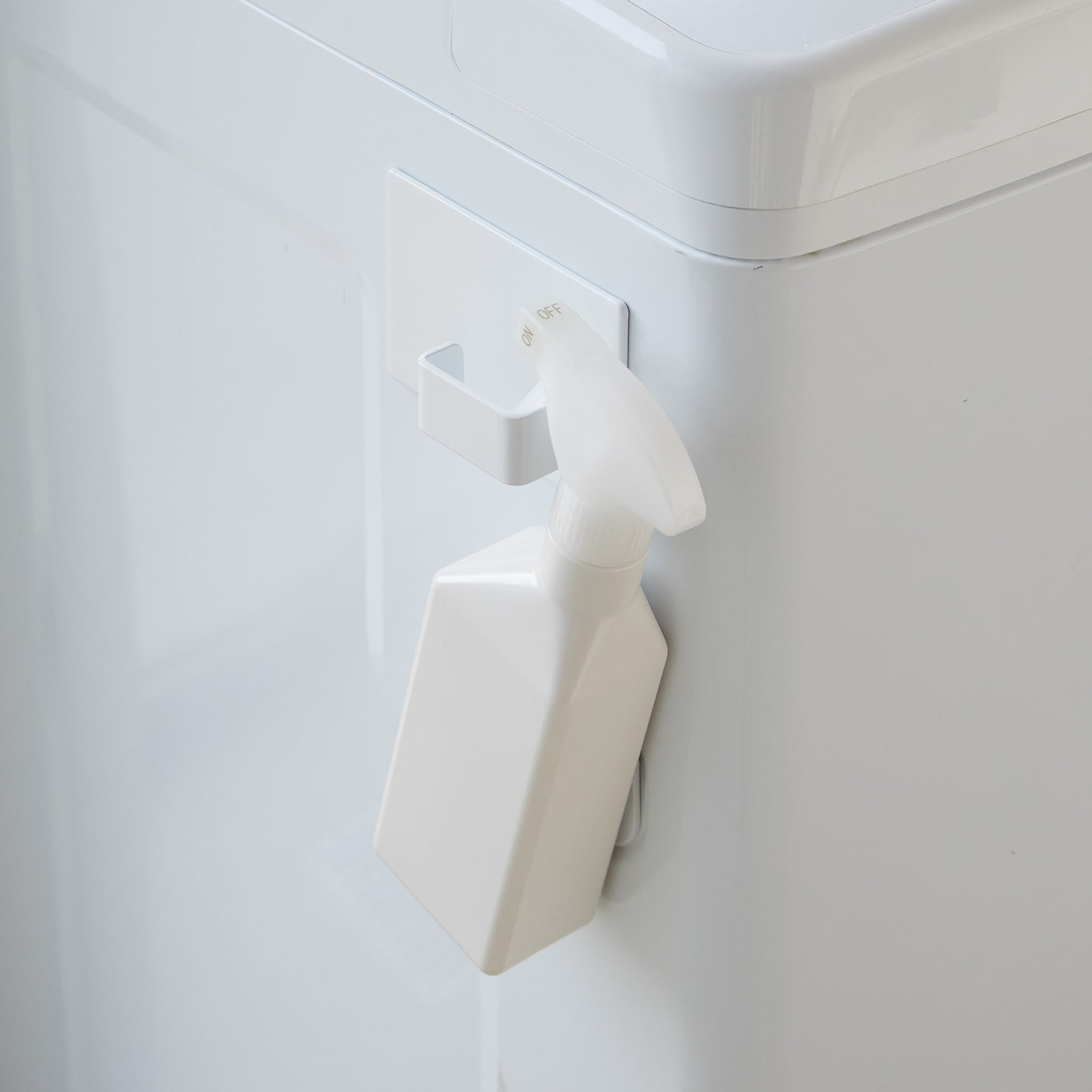 Magnetisk hvit krok på vaskemaskin for oppbevaring av tøy.