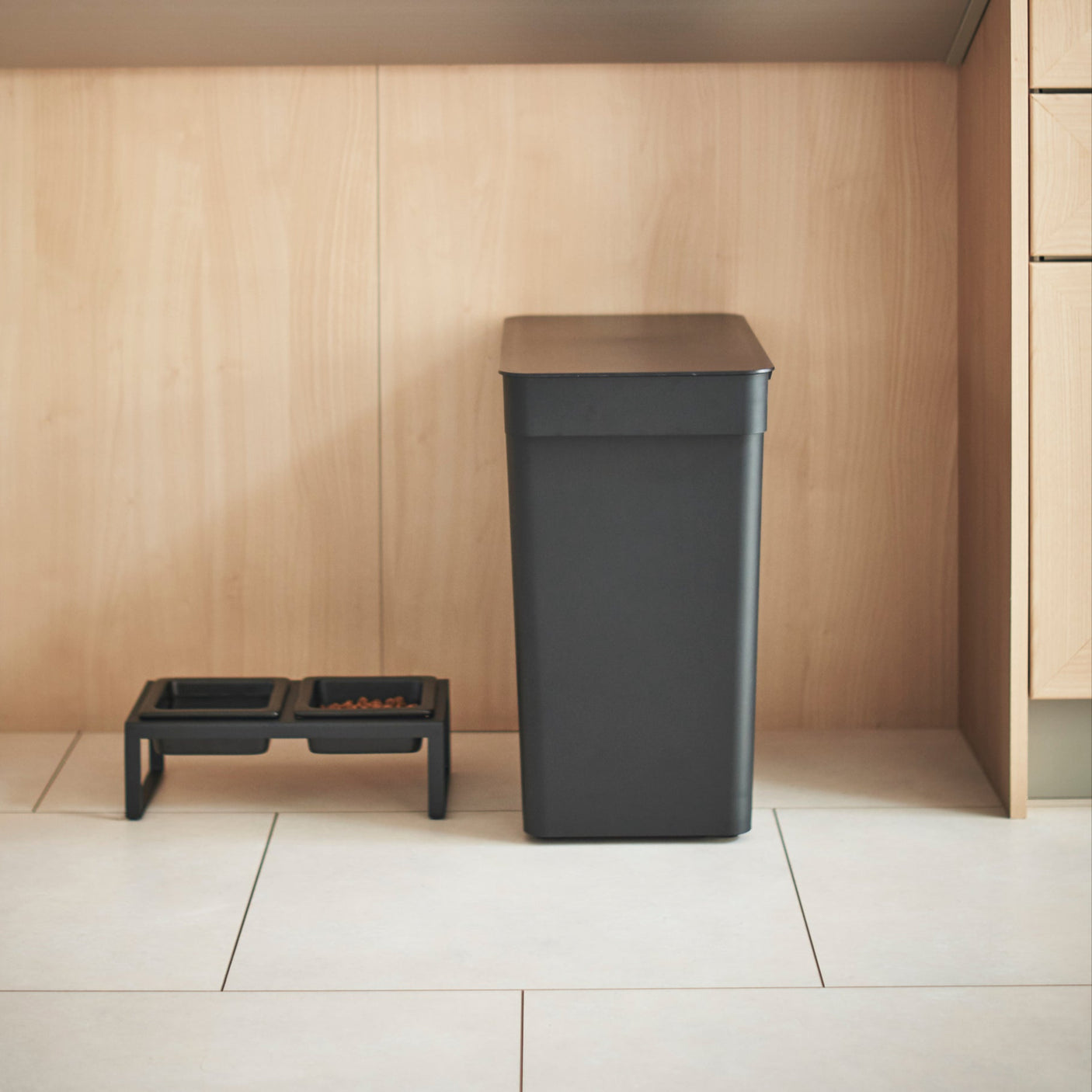 Stilren sort boks for ryddig og organisert lagring av fôr.