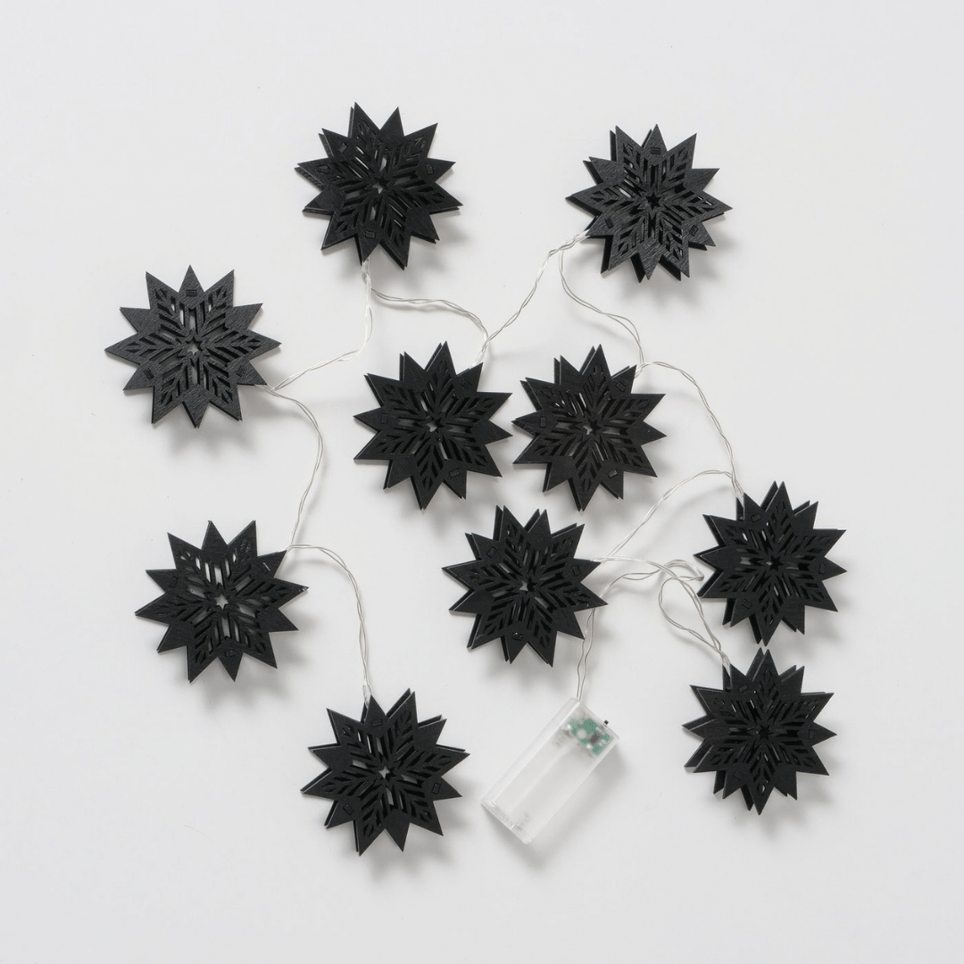 Nærbilde av sort stjernedesign på lyslenken med LED-lys.