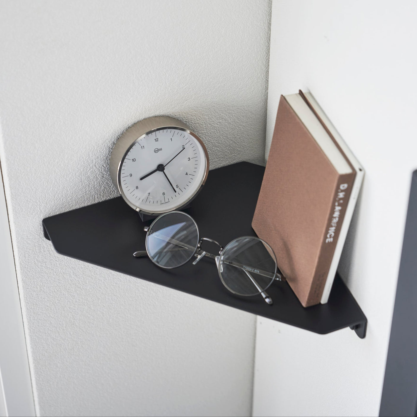 Stilig og funksjonell hylle for bøker og briller.