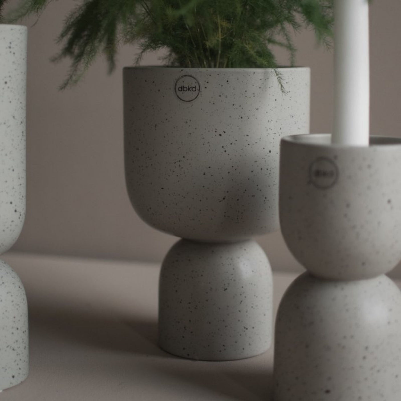 Flere DBKD Post potter i beige keramikk med planter i moderne interiør