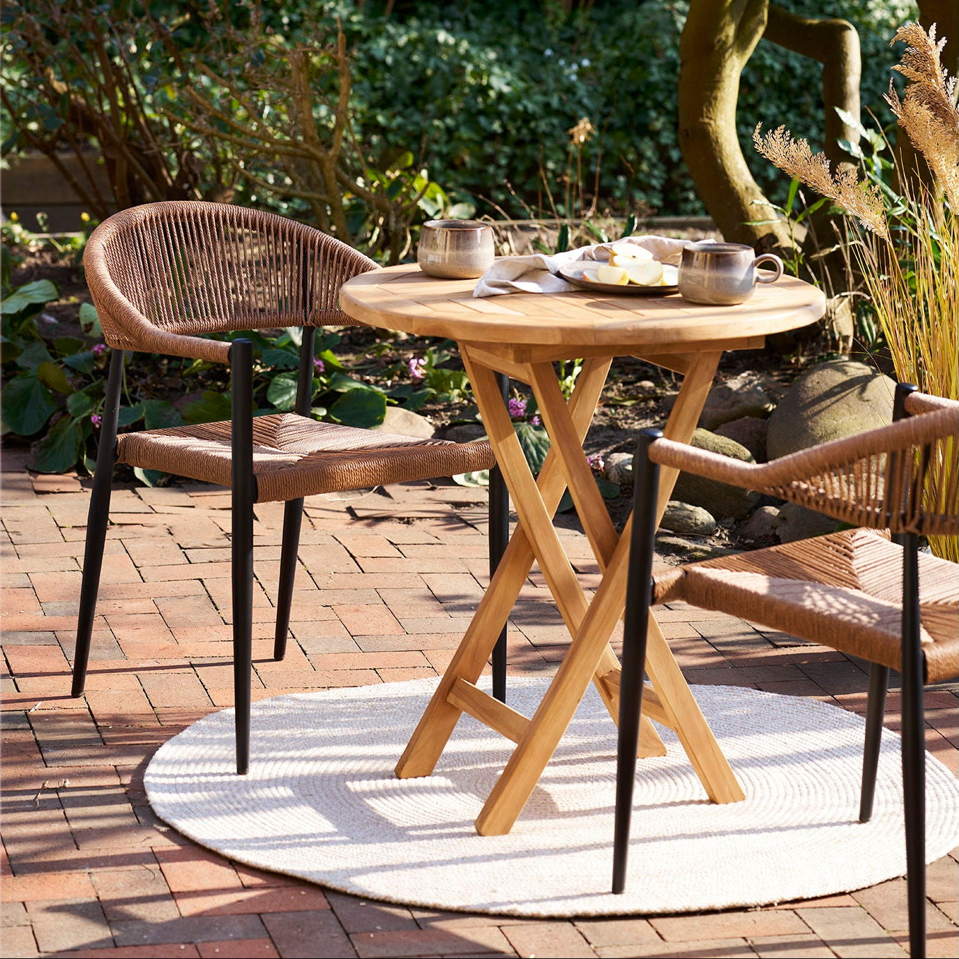 Natur og sort spisestol med flettet sete og rygg til uteplass