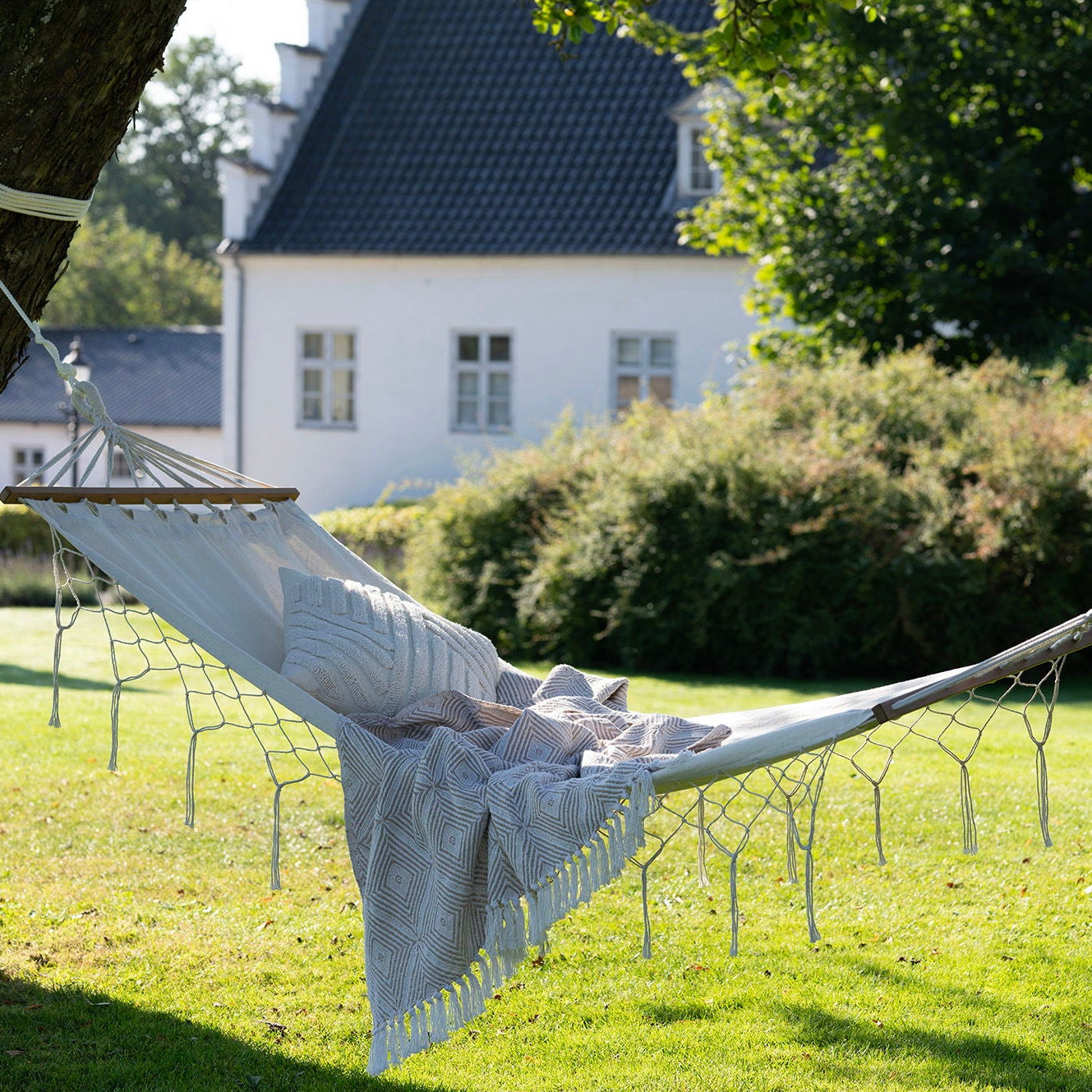 Luessa hammock brukt i grønt hagemiljø på sommerdag