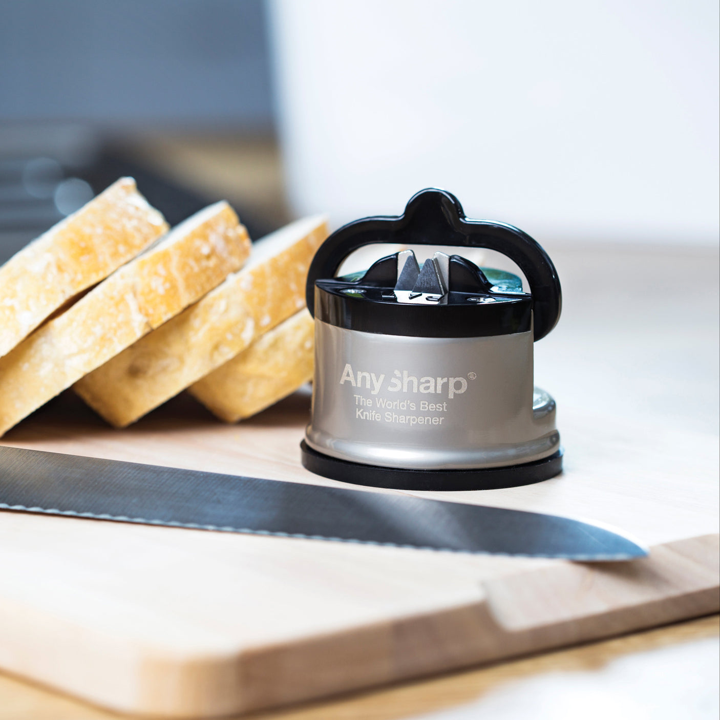 AnySharp knivsliper på kjøkkenbenk med grønnsaker og kokkekniv