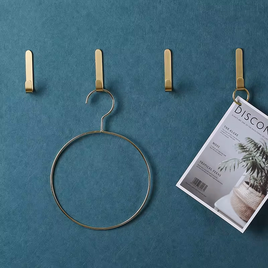 Moderne messingknagger i gull på vegg, brukt til håndklær, badekåper og interiørdetaljer.