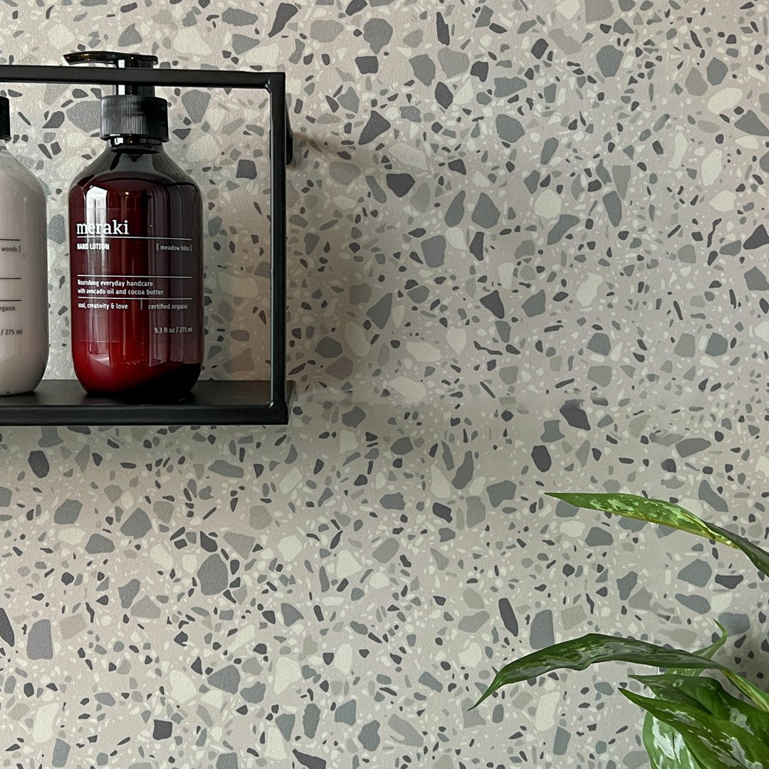 London terrazzo selvklæbende fliser på badervægg med såpeflaske og sort metallhylle