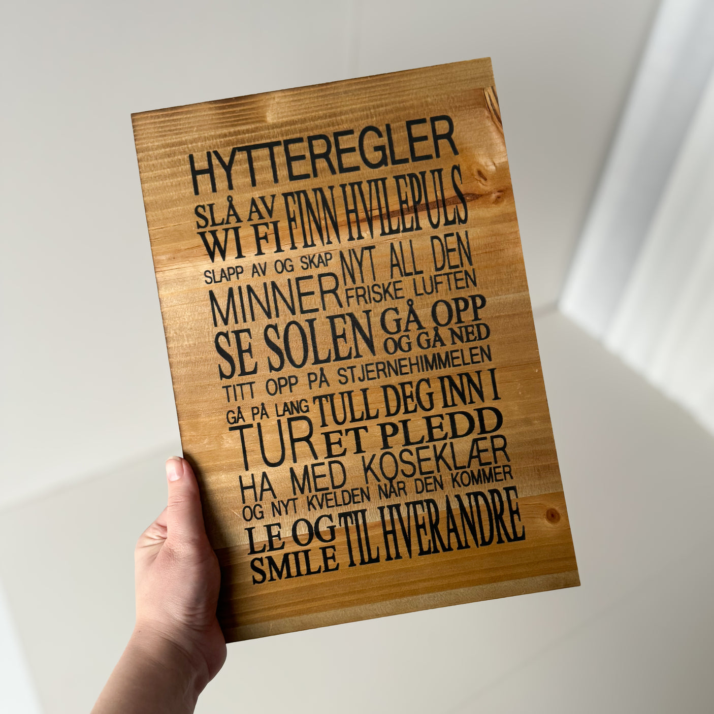 Dekorativt skilt med humoristisk tekst for hytteinteriør.