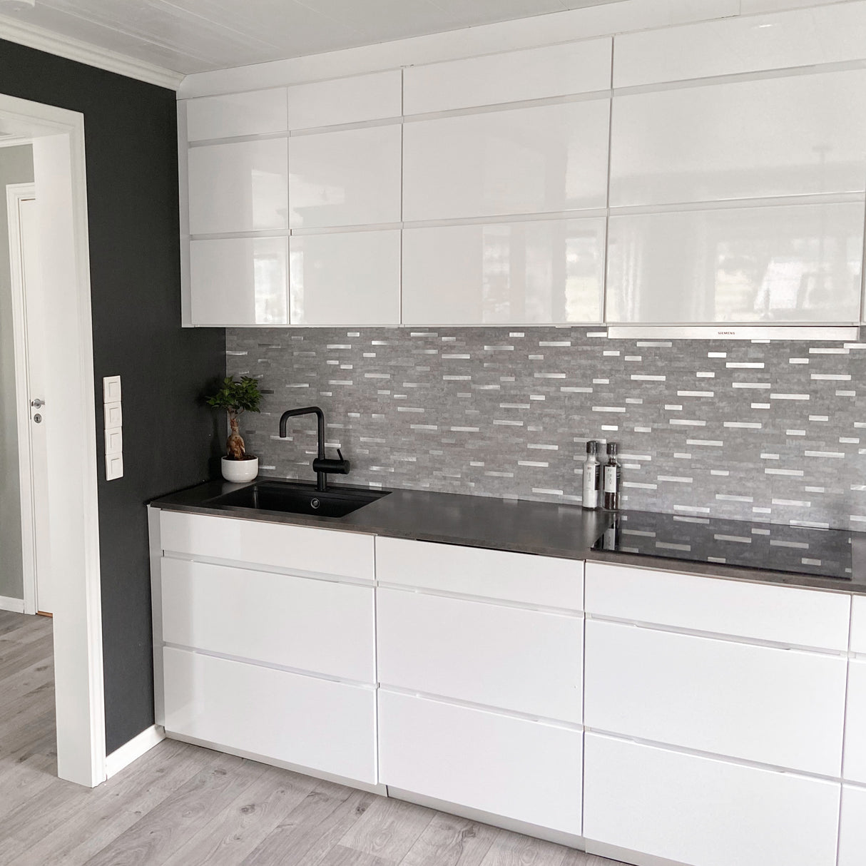 Grå flisoverflate med elegante innslag av børstet aluminium.