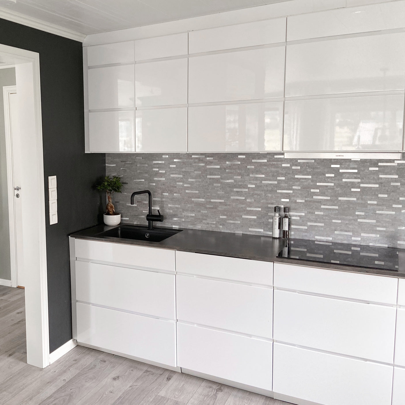 Grå flisoverflate med elegante innslag av børstet aluminium.