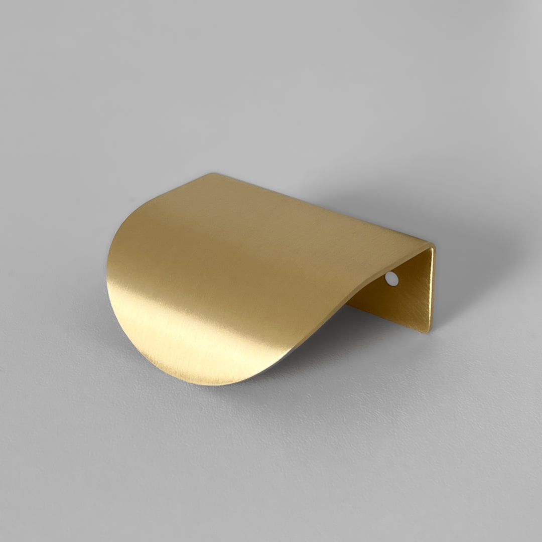 Roma håndtak i børstet messing med mykt buet form, vist mot nøytral bakgrunn.