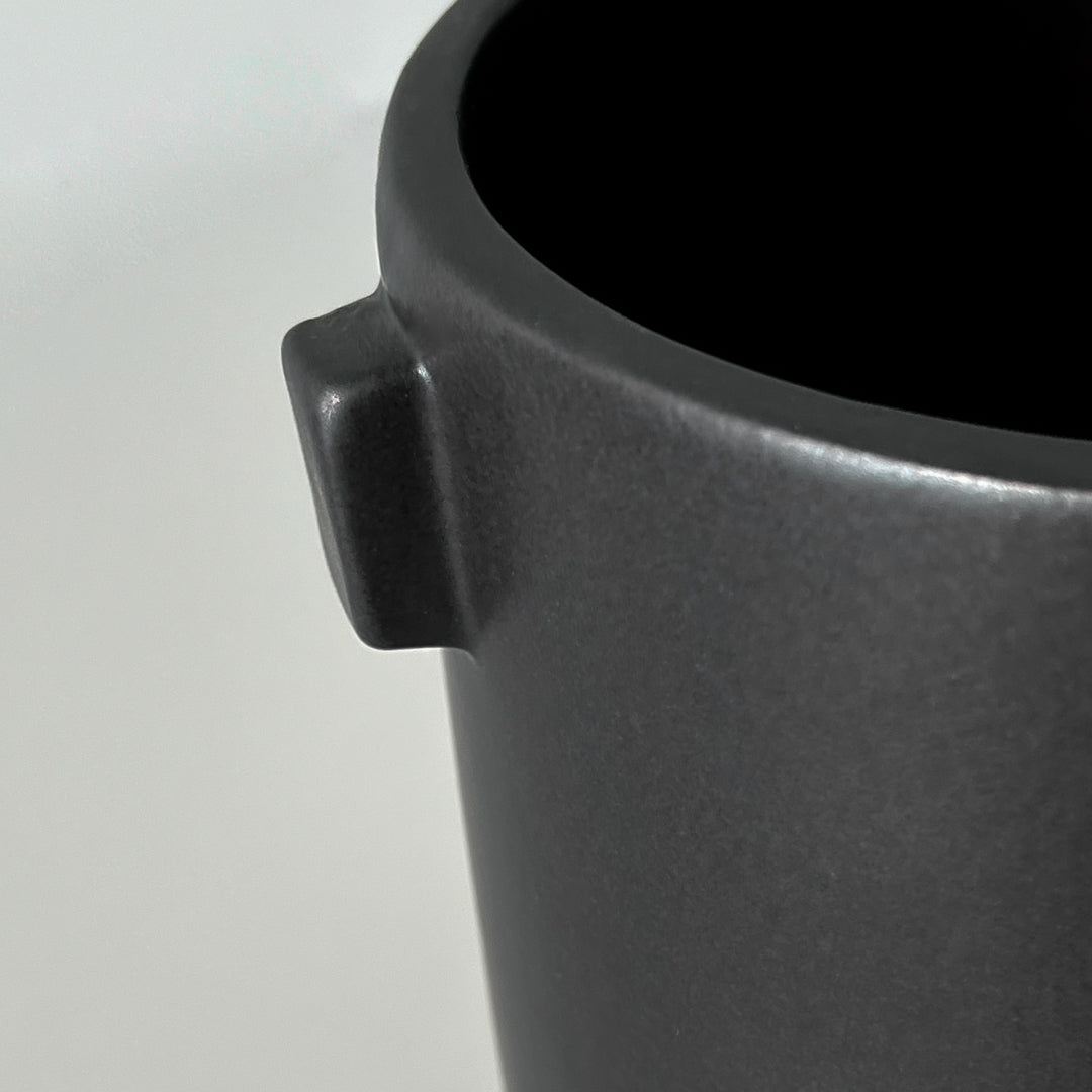 Nærbilde av Justine sort potte i steingods med matt overflate.