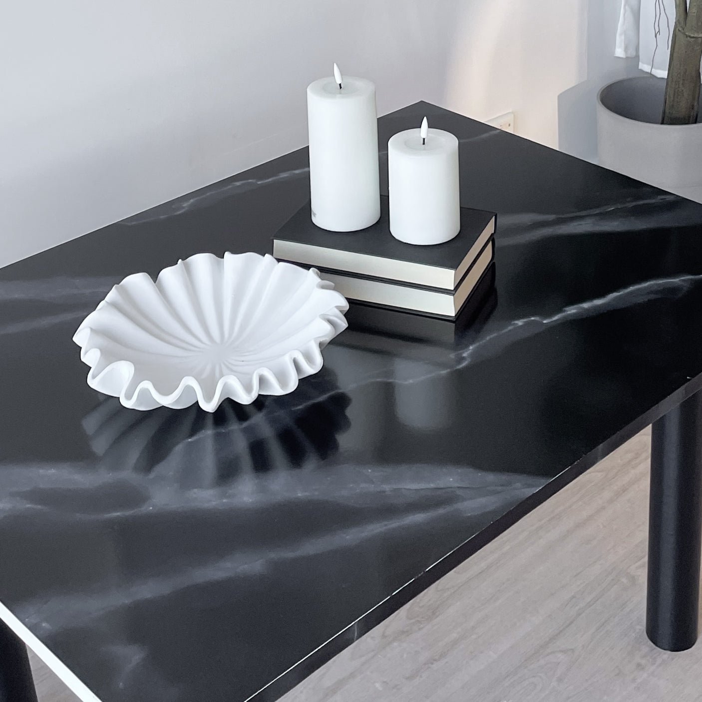 Nærbilde av selvklebende kontaktplast i sort marmordesign med hvite årer.