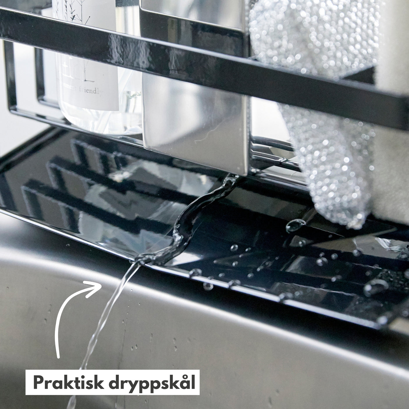 Såpeholder i bruk ved kjøkkenvask som organiserer rengjøringsartikler.