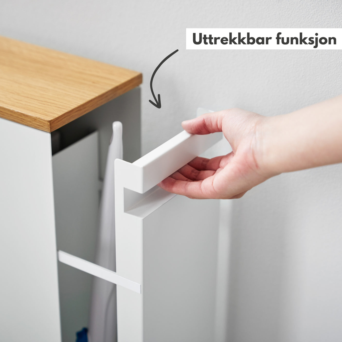 Hvit skyvehylle på hjul med plass til rengjøringsartikler og toalettruller, brukt i moderne bad.