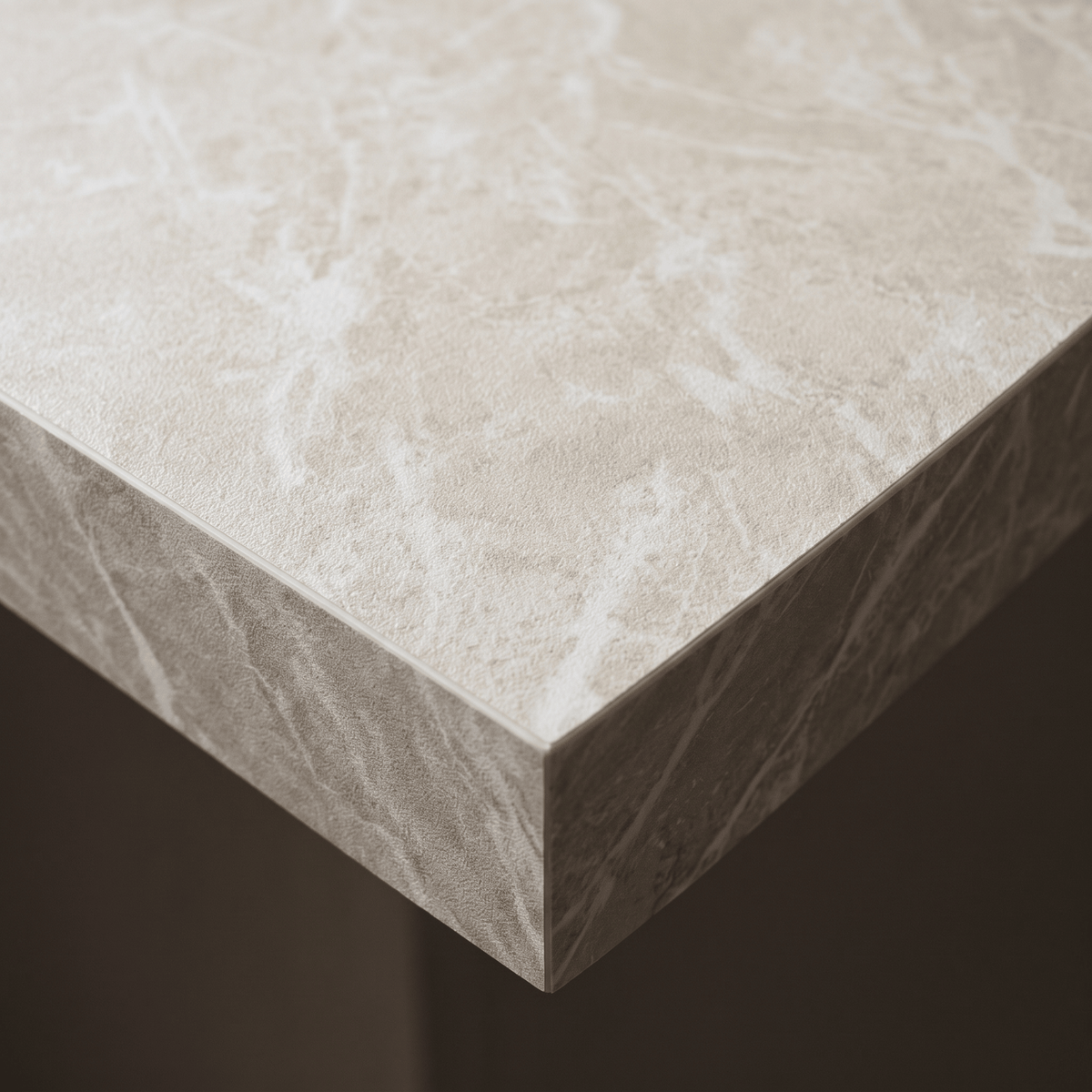 Nærbilde av benkeplatekant dekket med Limestone crema kontaktplast, kremhvit kalksteinsstruktur