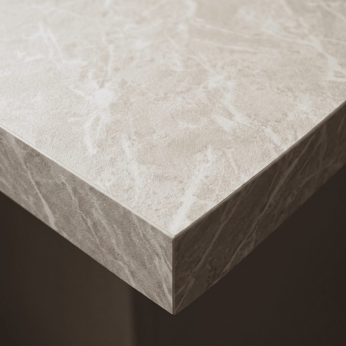Nærbilde av benkeplatekant dekket med Limestone crema kontaktplast, kremhvit kalksteinsstruktur