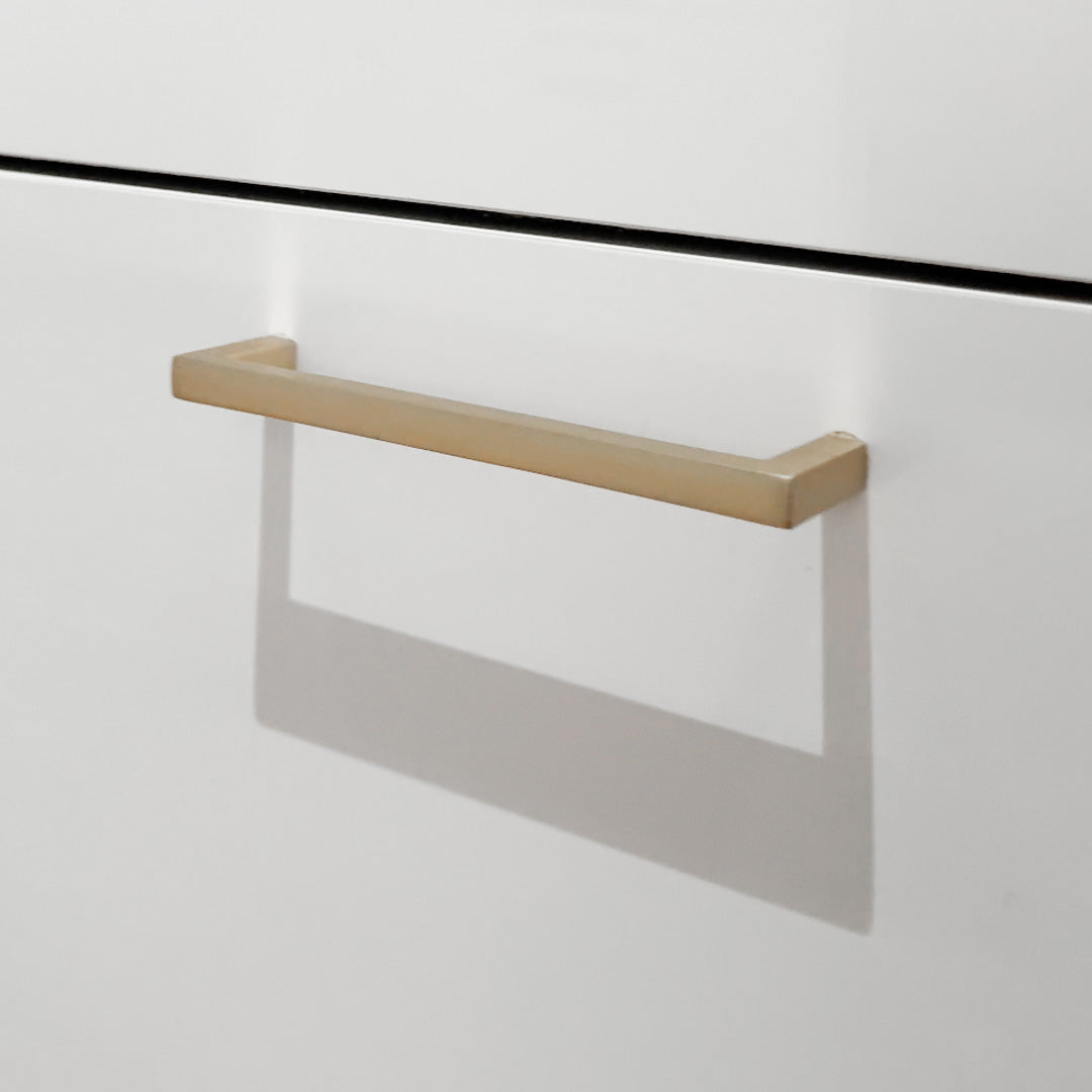 Nærbilde av messingfarget møbelhåndtak.