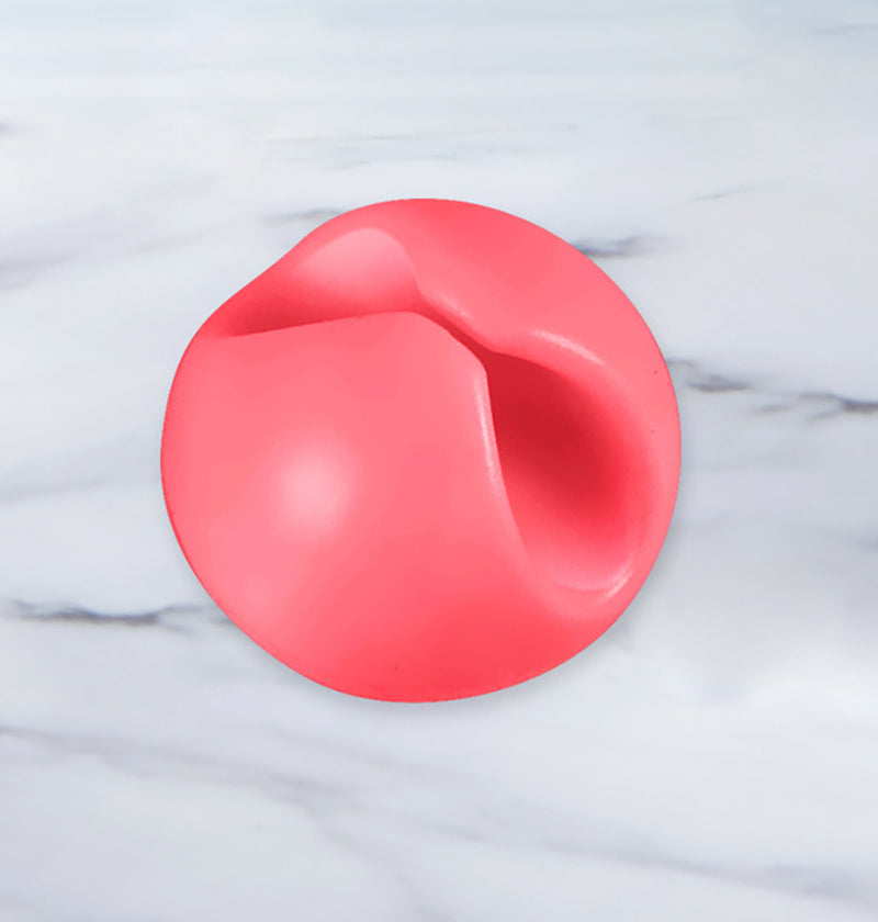 Nærbilde av en rød kabelorganisator festet til et underlag med en ledning i midten.