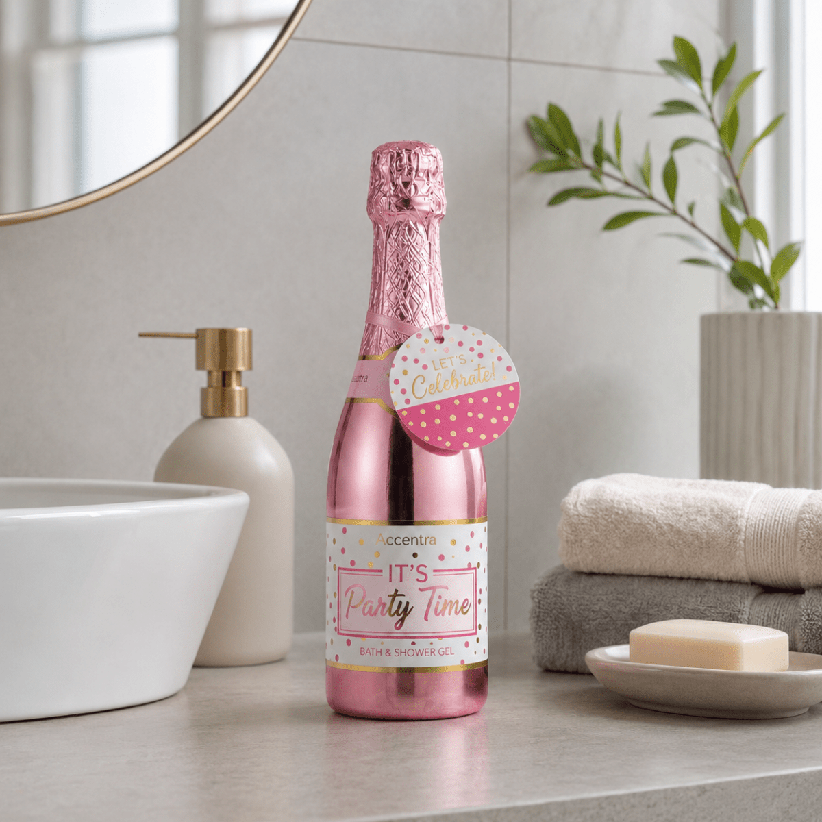 Rosa bad- och duschsåpe i champagneflaska på badrumsbänk i lyst, nordiskt badrum