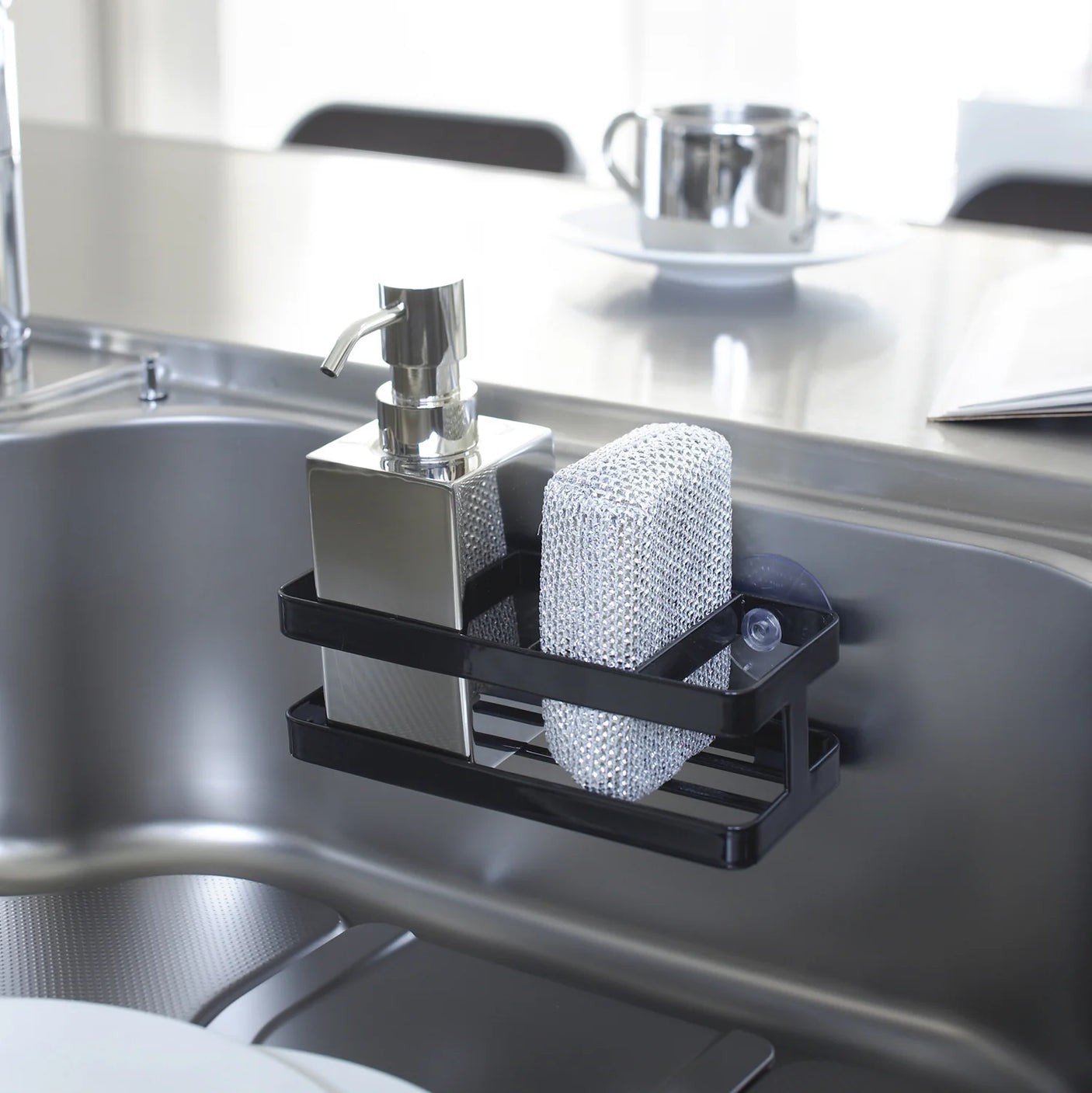 Svart svampholder og flaskeholder med sugekopp til kjøkkenvask