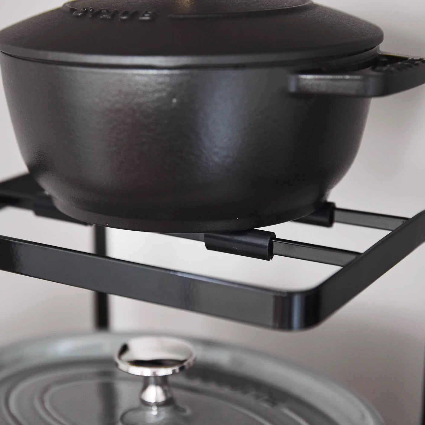 Svart kjøkkenstativ for gryter, lokk og små kjøkkenartikler