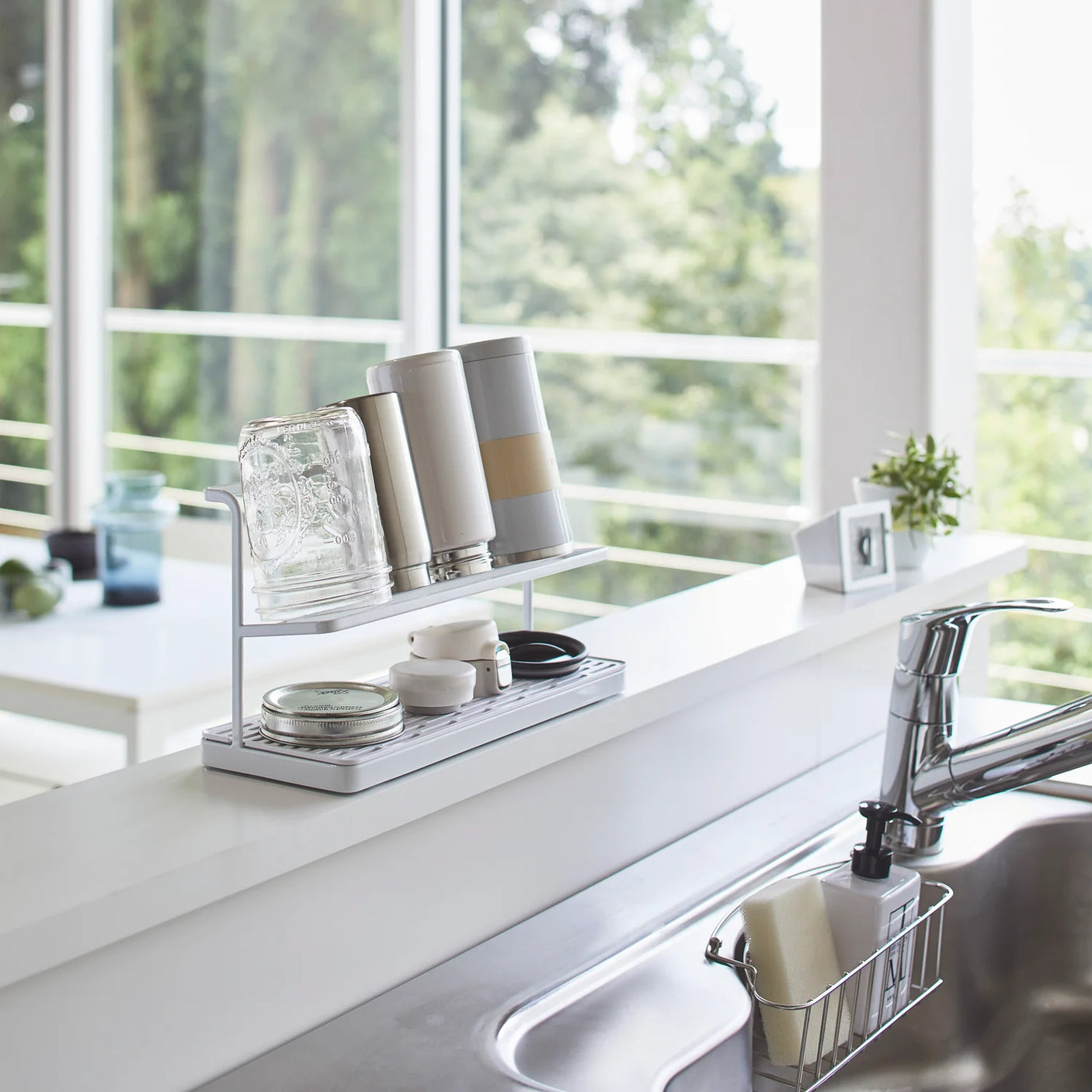 Hvitt stativ til lufttørking av flasker og tilbehør på benk