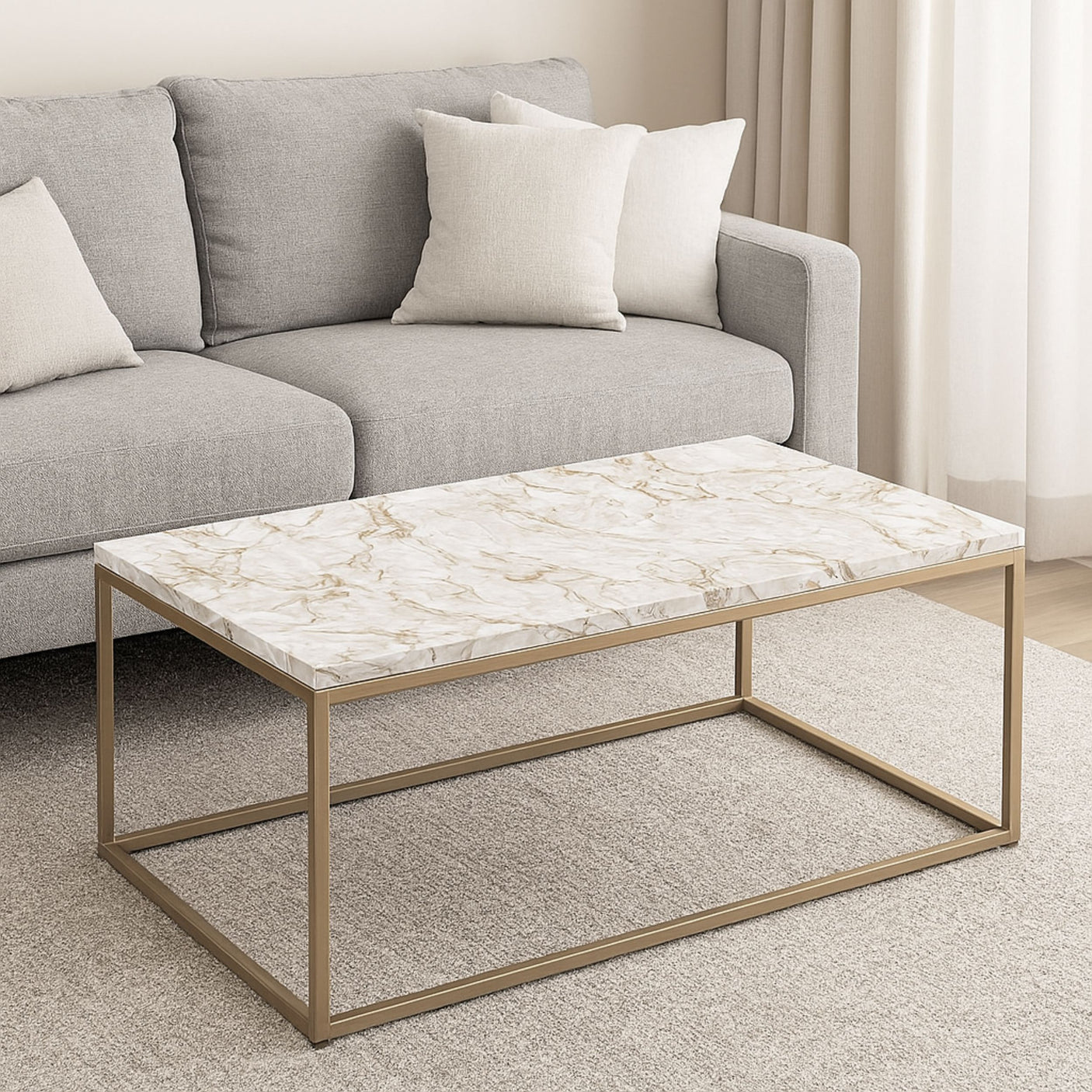 Elegant stuebord med gyllent understell og marmorlook kontaktplast foran grå sofa og lyse tekstiler i moderne og lyst interiør.