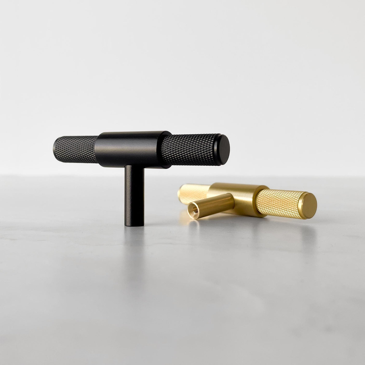 Elegant sort T-bar håndtak med riflet tekstur, perfekt til kjøkken og baderom.