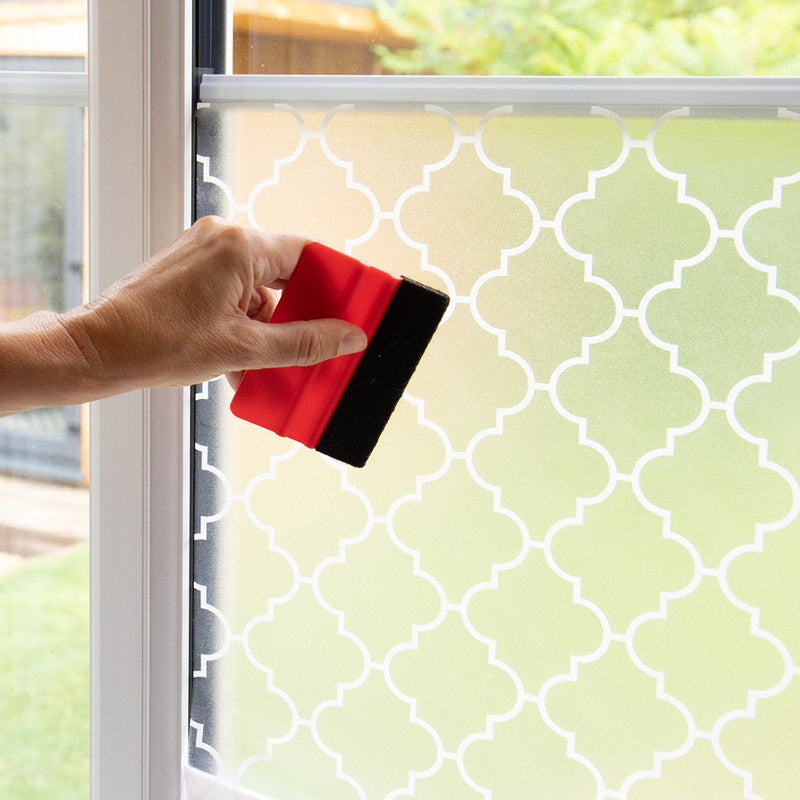 Nærbilde av Onadi mønstret vindusfolie i hvitt på glass.